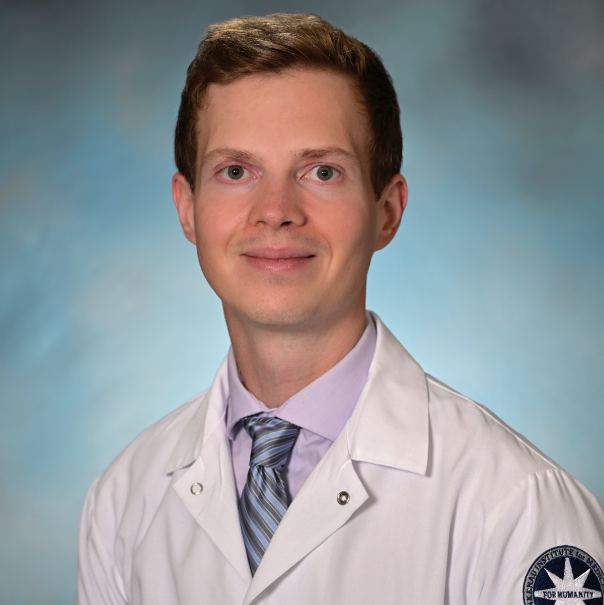 Professional portrait of Dimitrios Magouliotis in a white coat.